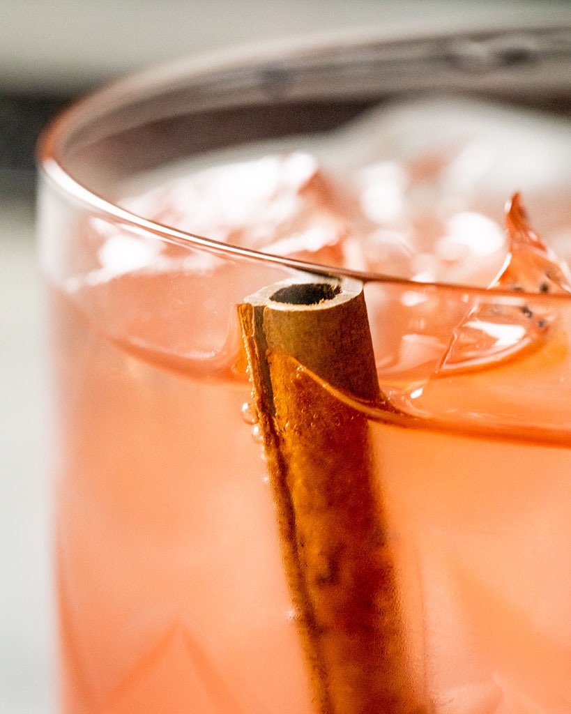 Cinnamon resting in a cocktail to infuse it with flavor