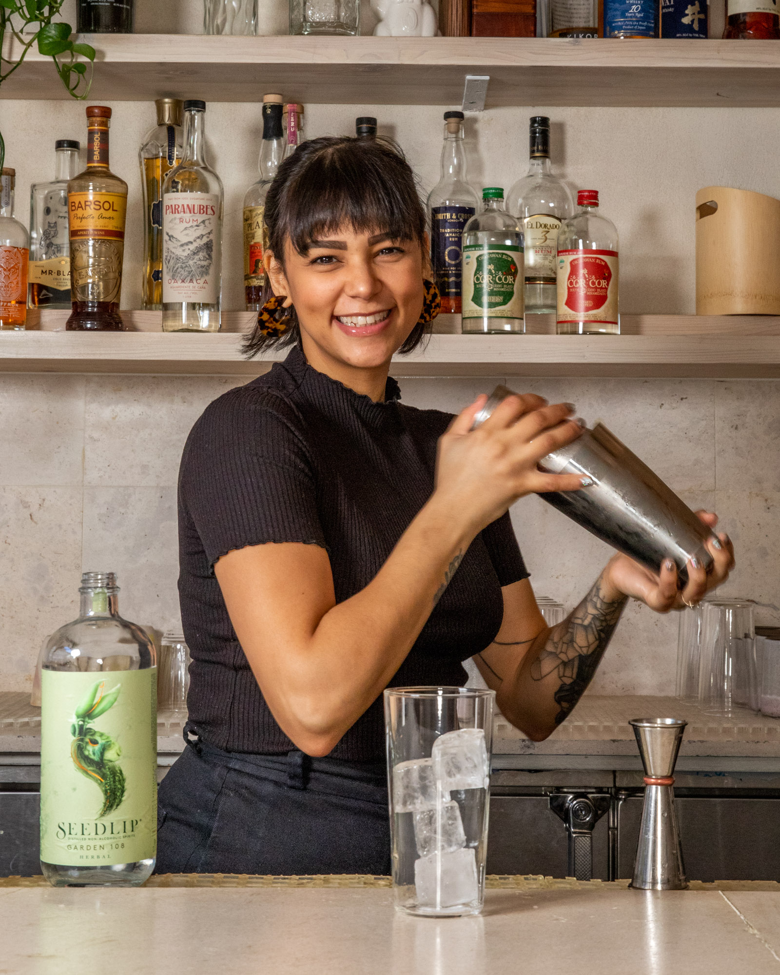 A happy smiling bartender shaking a cocktail